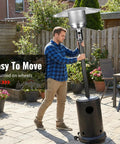 Person adjusting Heavy Duty 50000 BTU Outdoor Propane Patio Heater On Wheels With Easy Push Button Ignition for patio use