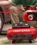 Compact 1.5 Gallon Oil Free Portable Air Compressor for DIY Projects delivers 1.5 CFM at 90 PSI in action inflating a car tire