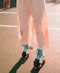 Person skating on outdoor court with black Two Pack Roller Skate Toe Cap Guards Protectors PU Leather Toe Covers for Quad Skates.
