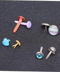 Colorful Metal Brads Fasteners Set For DIY Crafts Scrapbooking And Cardmaking Easy To Use Embellishment Kit With Storage Box Vibrant Colorful Staples For Creative Projects And Paper Craft Decor assorted brads on dark surface