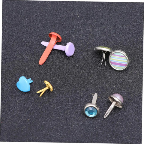 Colorful Metal Brads Fasteners Set For DIY Crafts Scrapbooking And Cardmaking Easy To Use Embellishment Kit With Storage Box Vibrant Colorful Staples For Creative Projects And Paper Craft Decor assorted brads on dark surface