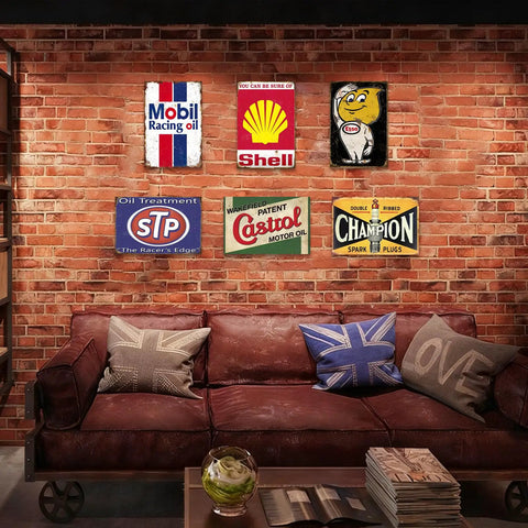 Kickass Vintage Metal Tin Signs Set Of Six Retro Garage Wall Decor Featuring Distressed Oil And Gas Station Prints For Awesome Man Cave Badass Automotive Wall Art displayed in a cozy brick-walled room.