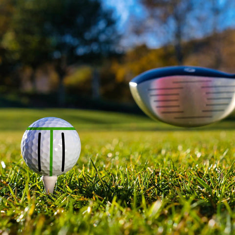 Golf ball on tee with alignment marks, part of 8 Pack Precision Golf Ball Marker Set With 4 Color Marking Stencils And 4 Vibrant Markers