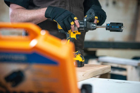 Spyder 6-1/4-inch carbide-tipped hole saw attached to a drill cutting wood on a workbench in a workshop.