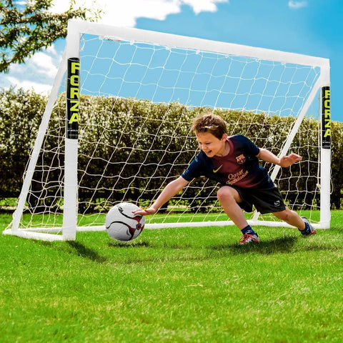 Child playing soccer with 6x4 Ft Kids Soccer Goal For Backyard Fun With Lightning Fast Setup Unbreakable Frame And Easy Two Minute Assembly