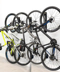 Swivel Wall Mount Bike Rack For Indoor Storage With Space Saving Design And Swivel Arms No Fuss Easy Roll In Access For Home Garage And Bike Park Fits Road Bikes Up To Two Point One Inch Tire Width holding multiple bikes in a garage.