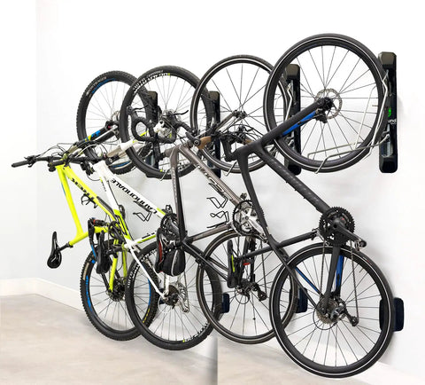 Swivel Wall Mount Bike Rack For Indoor Storage With Space Saving Design And Swivel Arms No Fuss Easy Roll In Access For Home Garage And Bike Park Fits Road Bikes Up To Two Point One Inch Tire Width holding multiple bikes in a garage.