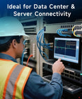 Side view of a data center technician in hard hat and safety vest inspecting a rack with fiber cables and a monitor.