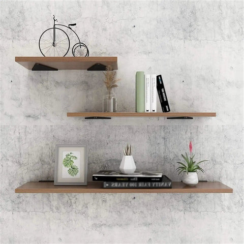 Rock Solid Heavy Duty Corner Brace Shelf Bracket Four Pack holding wooden shelves with books and decorative plants on gray wall.