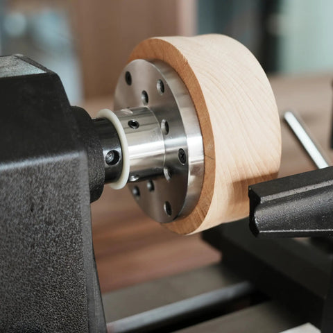 Close-up of Heavy Duty 1x8Tpi Face Plate Kit For Woodturning Lathes including wooden bowl on lathe with steel plate.