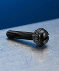 Black M2.5x18.5mm Tuner Peg Screw for Classical Guitar with slotted head on metal surface, secure fastening replacement part