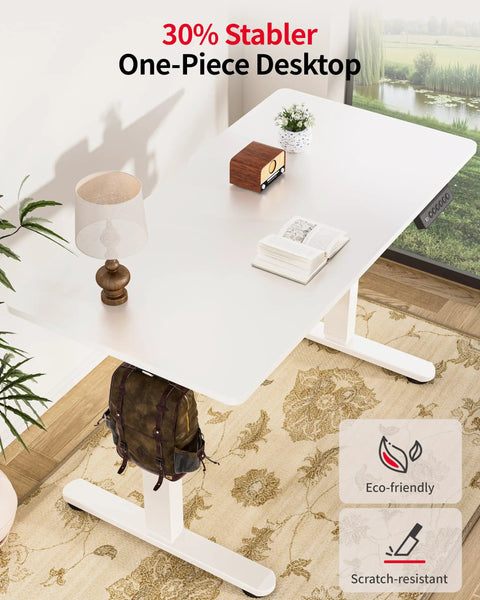Electric Standing Desk With Adjustable Height And Memory Presets Heavy Duty Steel Base Rolling Casters For Office Gaming Home Setup 48X24 Inches White with lamp, book, and backpack.