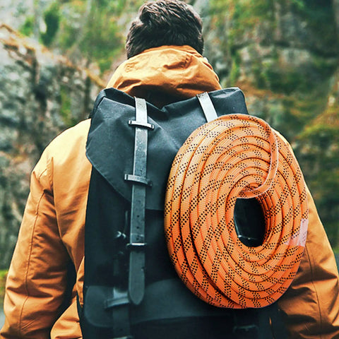 Hiker with a black backpack carrying 9/16 Inch Double Braid Polyester Rope 200 Ft Heavy Duty Pulling Line For Towing And Rigging