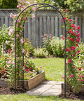 Heavy Duty 86 Inch Steel Garden Arch Pergola Arbor With Ground Stakes For Climbing Plants Ideal For Weddings Parties And Backyard Decor Weatherproof Powder Coated Frame For All Seasons in garden setting with blooming flowers.