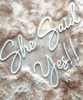 She Said Yes Neon Sign Large 23x16 Inch Warm White LED Flex Neon Light displayed on plush surface.