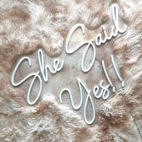 She Said Yes Neon Sign Large 23x16 Inch Warm White LED Flex Neon Light displayed on plush surface.