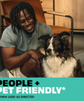 Man sitting next to a black and white dog indoors with the text 'People + Pet Friendly' displayed.