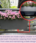 Super Sleek Two Pack Rail Planters For Balcony And Deck Twenty Inch Self Watering Garden Boxes In Matte Black with pink flowers.