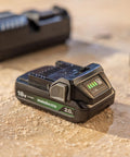 Close-up of an 18V cordless battery on a workbench, compatible with the 18V Cordless 5 Inch Random Orbital Sander With Top Notch Dust Collection