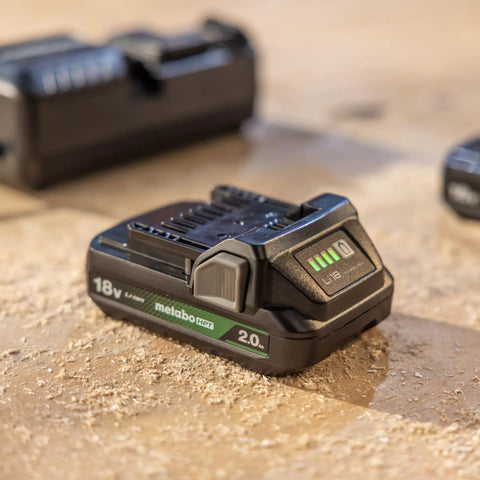 Close-up of an 18V cordless battery on a workbench, compatible with the 18V Cordless 5 Inch Random Orbital Sander With Top Notch Dust Collection