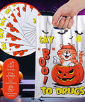 Say Boo To Drugs Halloween Reflective Gift Bags 150 Pack shown with cat in pumpkin design, hand holding a bag, spooky background.