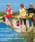 Three women walking on a beach holding red and black kites, ideal for outdoor adventures with durable construction.