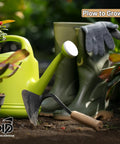 All Purpose Garden Hand Plow Hoe For Easy Weeding And Farming on soil, with green watering can and boots, gardening setup