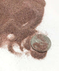 Garnet abrasive media, 100/120 grit, fine grade, brown loose blast grit with dime for scale