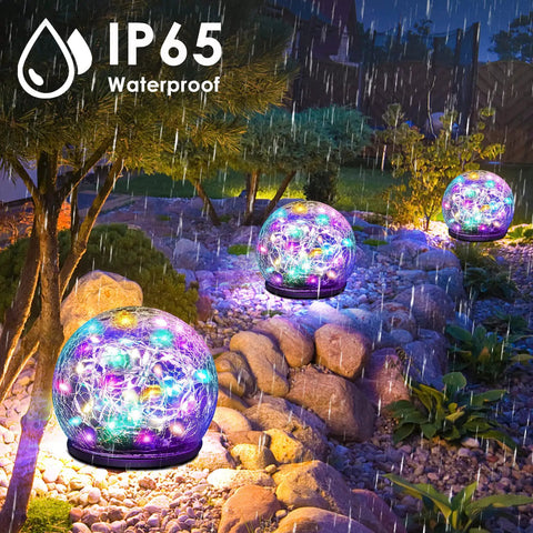 2 Pack Solar Garden Lights With 80 LED Colorful Cracked Glass Balls illuminating a rainy garden, showcasing IP65 waterproof rating.