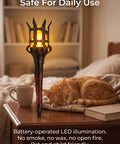 Close-up of Medieval LED Torch Wall Sconce Flickering Flame Castle Light (Red) beside a sleeping cat on a table.
