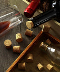 Close-up of wine bottles and glasses with 120 Piece 8 Sizes Tapered Cork Stoppers Set Natural Wood Wine Bottle Plugs.