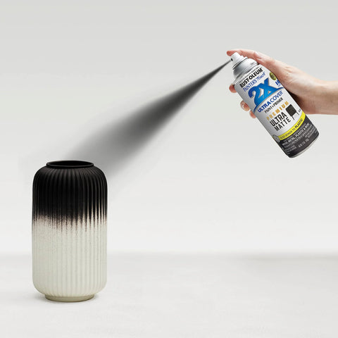 Rust-Oleum Painter's Touch 2X Ultra Cover spray paint can spraying matte black on a ribbed ceramic vase front view