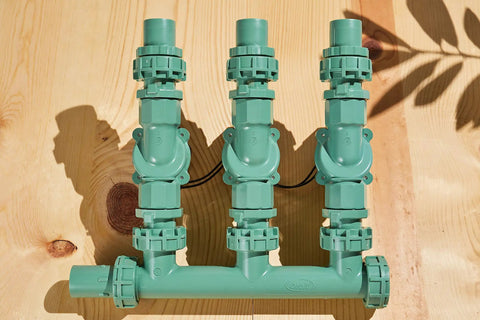 Heavy Duty 3 Valve Preassembled Irrigation Manifold with Swivel Unions for Quick No Fuss Multi Zone Valve Systems displayed on wood surface