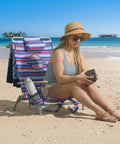 Woman sitting on 5-Position Lay Flat Folding Backpack Beach Chair With Aluminum Frame In Red White And Blue Stripe on beach