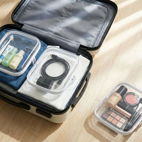 Slick Clear Hard Shell Zipper Case Set With 9 Multi Size Compartments, storing cosmetics and tech gear inside a suitcase.