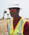 Worker wearing vented full brim hard hat with UV indicator sensor, construction site, ANSI Z87.1 certified, 4 point suspension, navy.