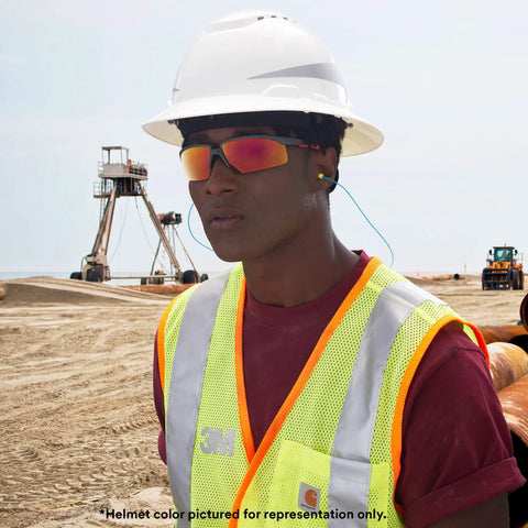 Worker wearing vented full brim hard hat with UV indicator sensor, construction site, ANSI Z87.1 certified, 4 point suspension, navy.