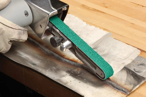 Cloth Grinding Belt 577F 3x132 In 80 YF-Weight, Alumina Zirconia Blend in use on metal surface, wet or dry use, heavy polyester backing.