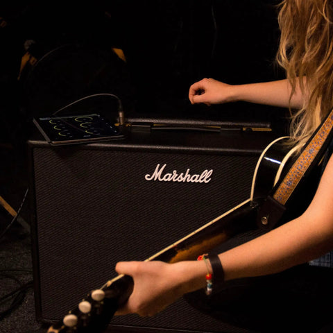 Musician using Marshall amp with guitar, similar to Code50 Digital Guitar Amplifier With Fifty Watt Output One Hundred Plus Presets.