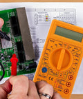 Hands using Digital Multimeter With Buzzer Three And A Half Digit LCD Display Voltage Current And Resistance Tester