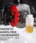 Installed Mission Automotive brake bleeder kit: white 16 oz magnetic bottle with tubing beside red brake caliper.