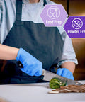 Person wearing blue Nitrile Vinyl Blend Exam Gloves Powder Free Latex Free Disposable Non Sterile Large while chopping vegetables