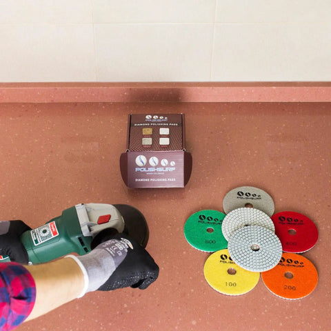 Pro Grade 4 Inch Diamond Polishing Pads Set For Wet Or Dry Use 7 Piece Kit displayed beside a hand using a polisher on a countertop