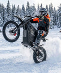 Rider performing a wheelie on Powerful 4000W Electric Dirt Bike For Teens And Adults with 45 MPH peak speed, snow background