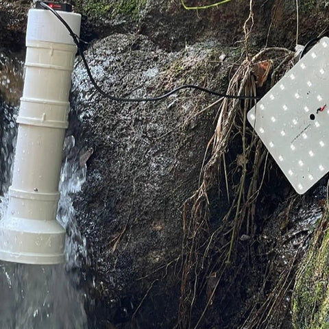 Go Anywhere 50W Portable Hydroelectric Generator With Spiral Turbine And USB Fast Charge installed near a stream