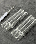 Six Pack Glass Tubes For High Temperature Use, Heat And Acid Alkali Resistant, Four Inch Length with cleaning brush on gray background.