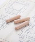100 Pcs Wooden Dowel Pins Round Unfinished Wood Dowels with fluted beveled ends placed on woodworking blueprints