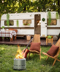 15 Inch Smokeless Outdoor Fire Pit For Patio Hangouts, Steel Portable Fire Pit with chairs and a guitar by a camper