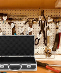 Kickass Aluminum Toolbox Carrying Case With Grip Handle on a workbench with hanging tools in the background.