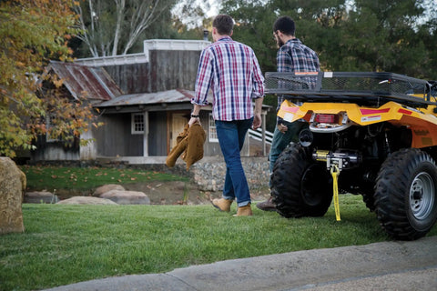 Men walking away from ATV with Rugged 3500 Pound ATV And UTV Synthetic Rope Winch Kit in outdoor setting